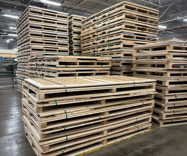 Stacked knock-down wooden crates organized for warehouse storage and shipment.