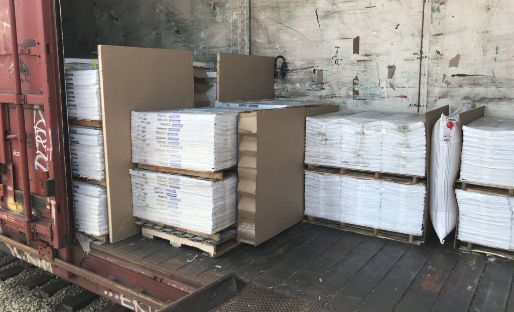 Corrugated void fill products complementing airbags in a customized railcar load securement system.
