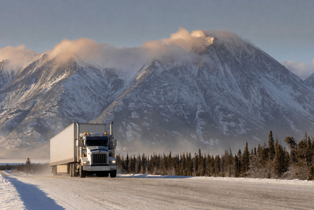 Altitude and temperature shifts, represented by the mountains in this picture, can impact airbags used for load securement, as with the logistics trucks on this road.
